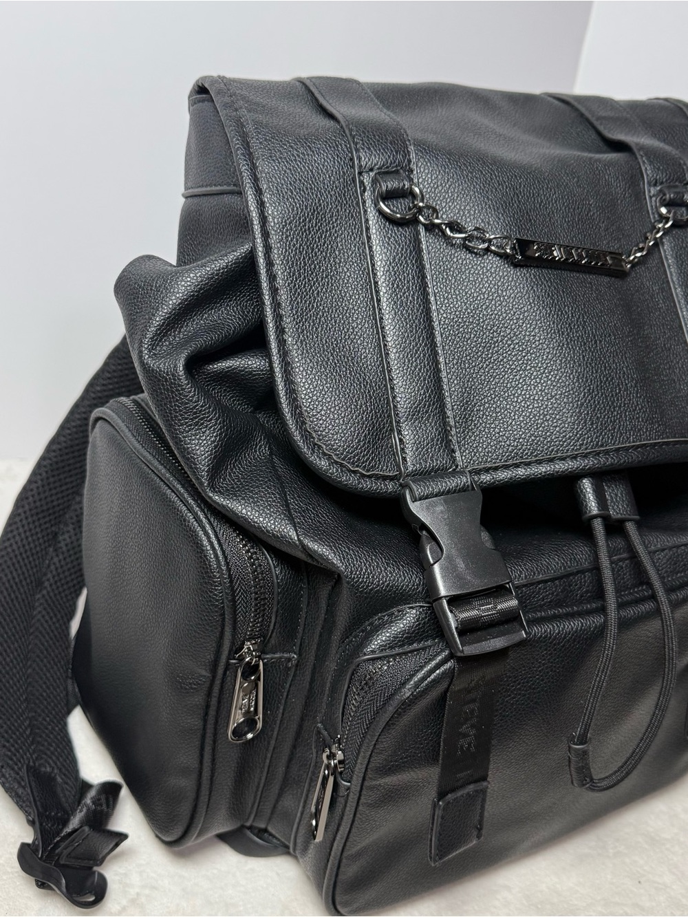 Steve Madden Black Pebbled Faux Leather Drawstring Backpack with Chain Trim - Picture 2 of 8